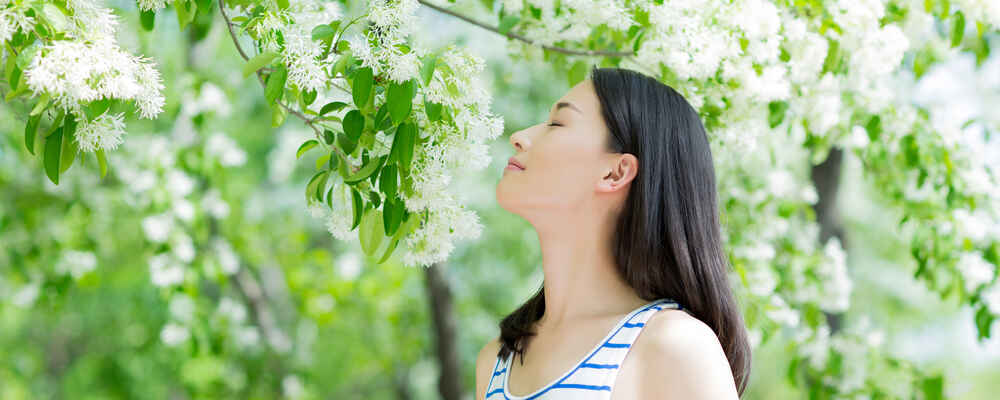 Woman smelling flowers after allergy relief