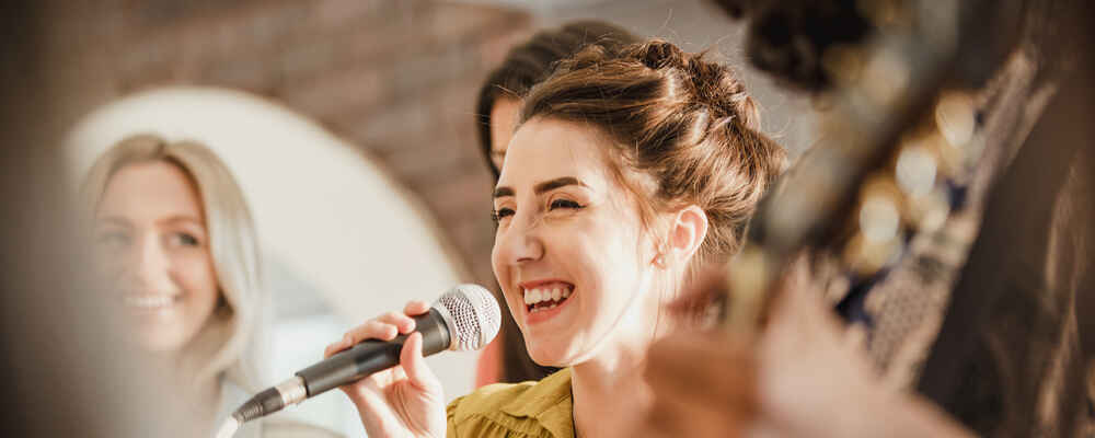 Woman smiling and speaking into microphone without voice issues