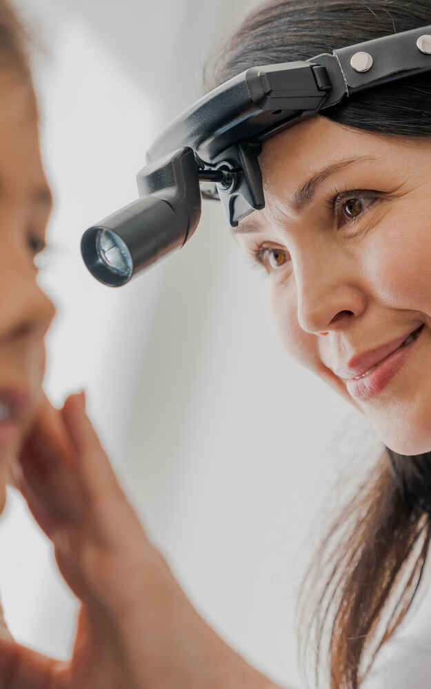 Close-up of professional otolaryngologist examining a patient's ear