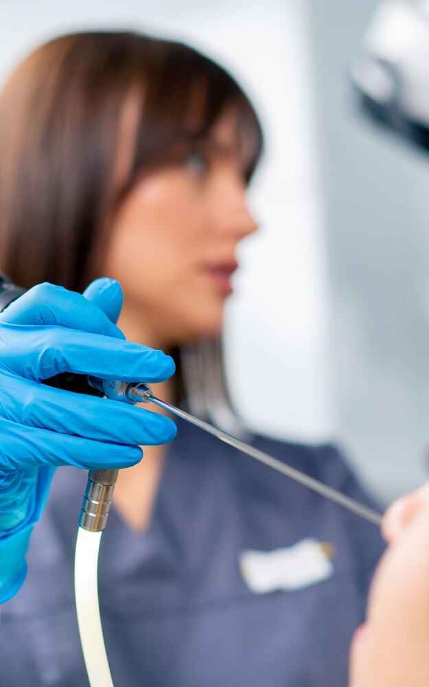 ENT doctor using nasal endoscope to check patient's nose for issues