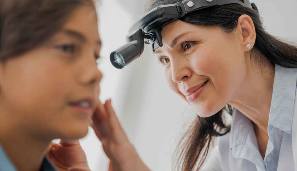Close-up of professional otolaryngologist examining a patient's ear