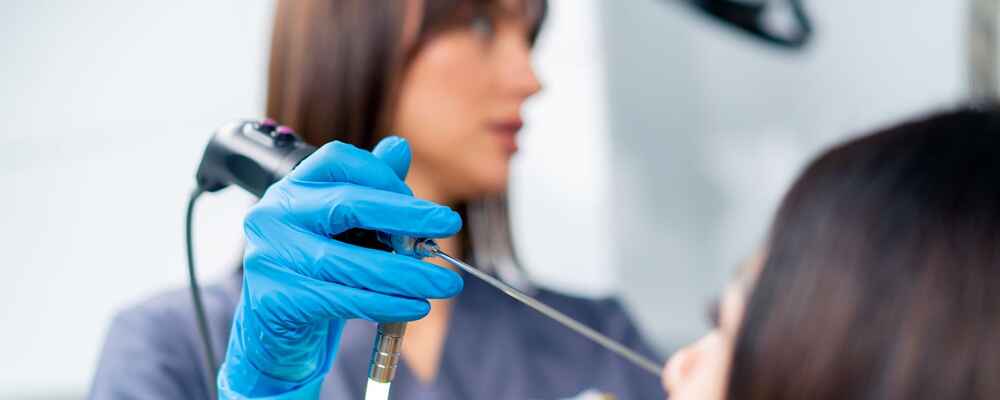 ENT doctor using nasal endoscope to check patient's nose for issues