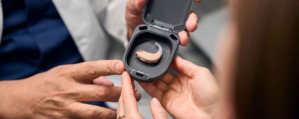 Audiologist showing patient her new hearing aids