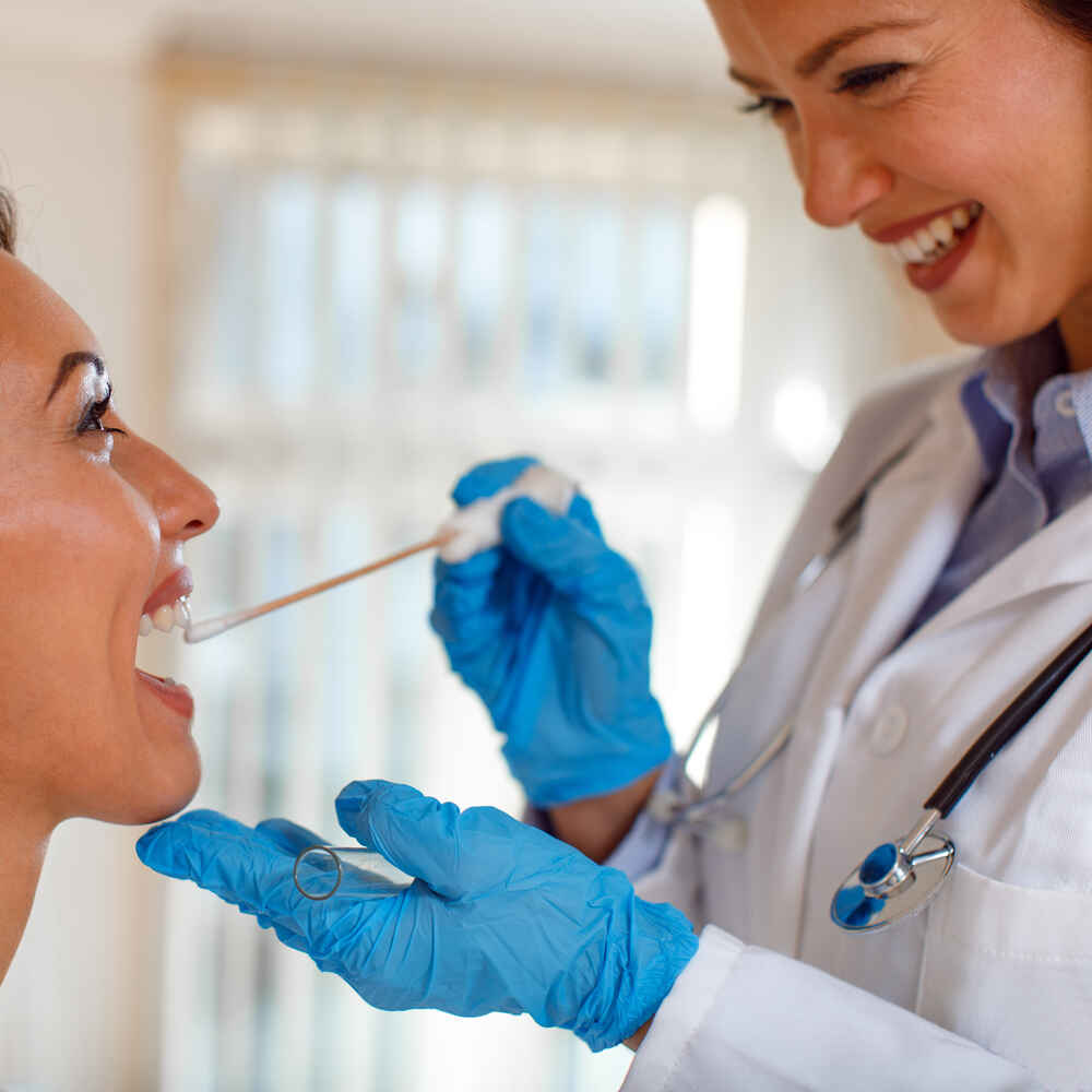 ENT doctor examining patient's mouth to check for cause of voice issues